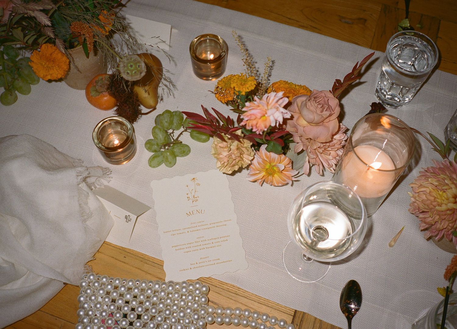 Elegant table settings with candles and floral decorations at wedding reception.