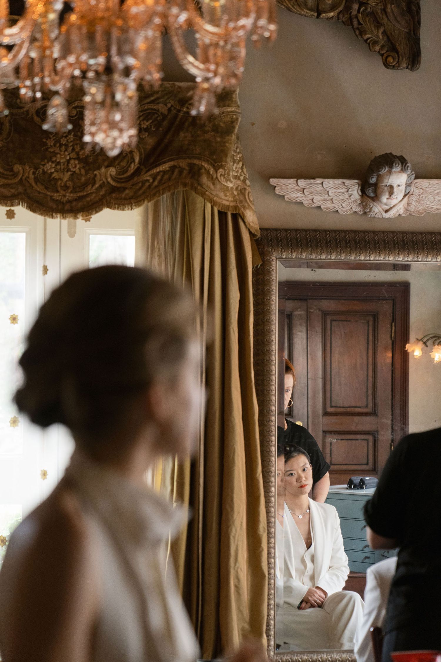 Elegant chandelier and gold curtains create a romantic ambiance in a historic room setting.