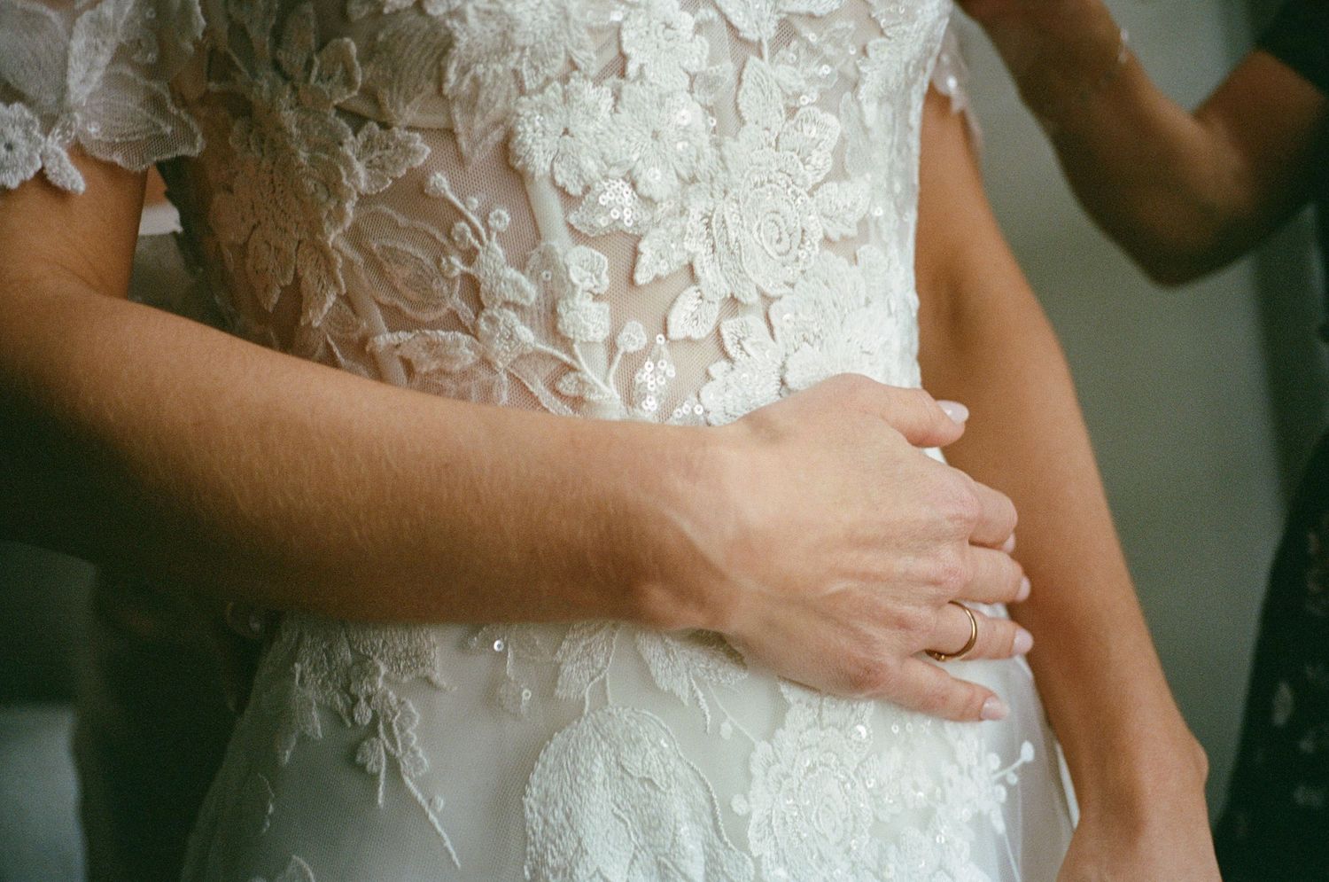 Detail shots of intricate lace patterns on a white wedding dress.