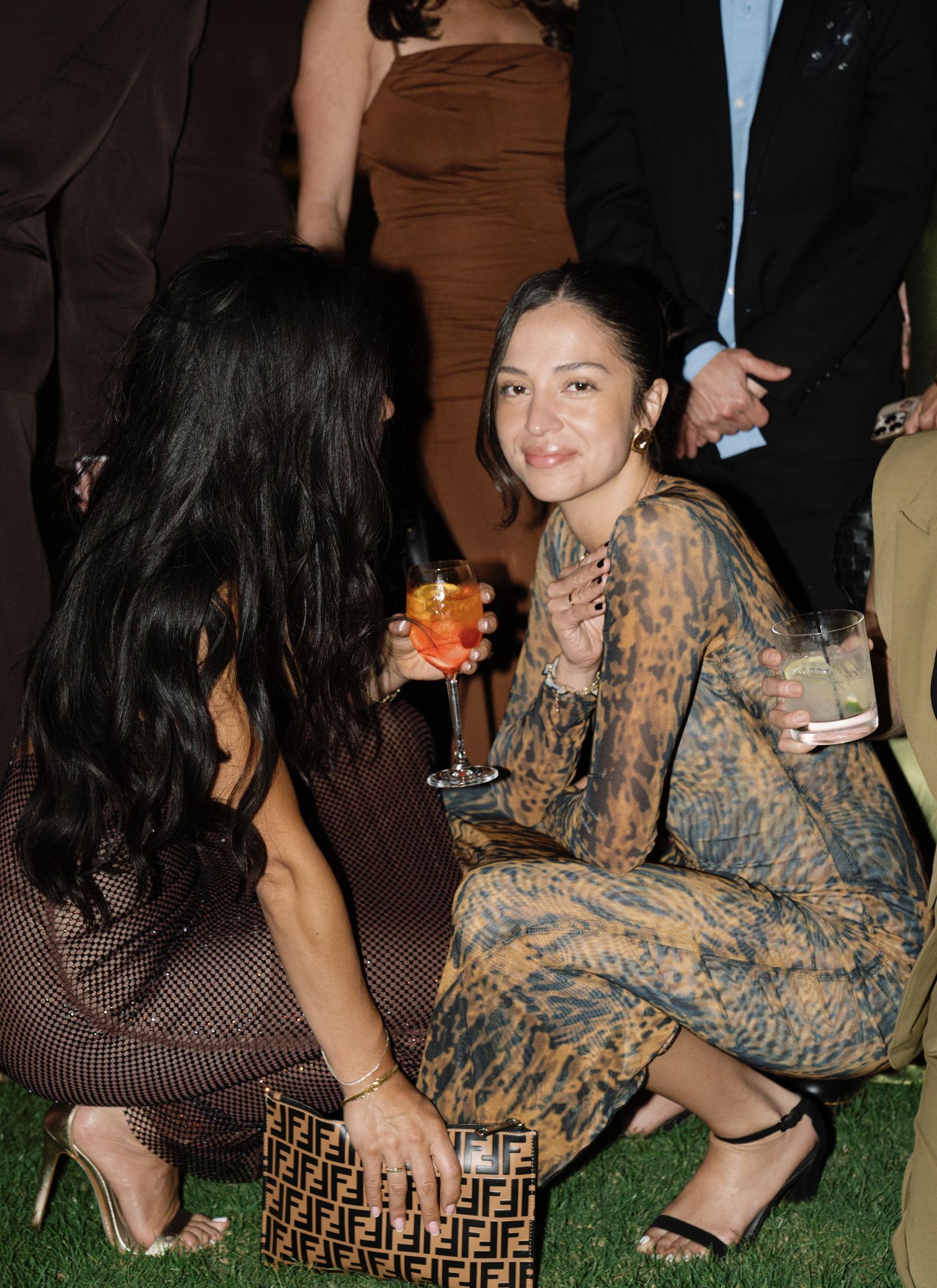 Guests sitting on designer patterned furniture at an outdoor evening event.