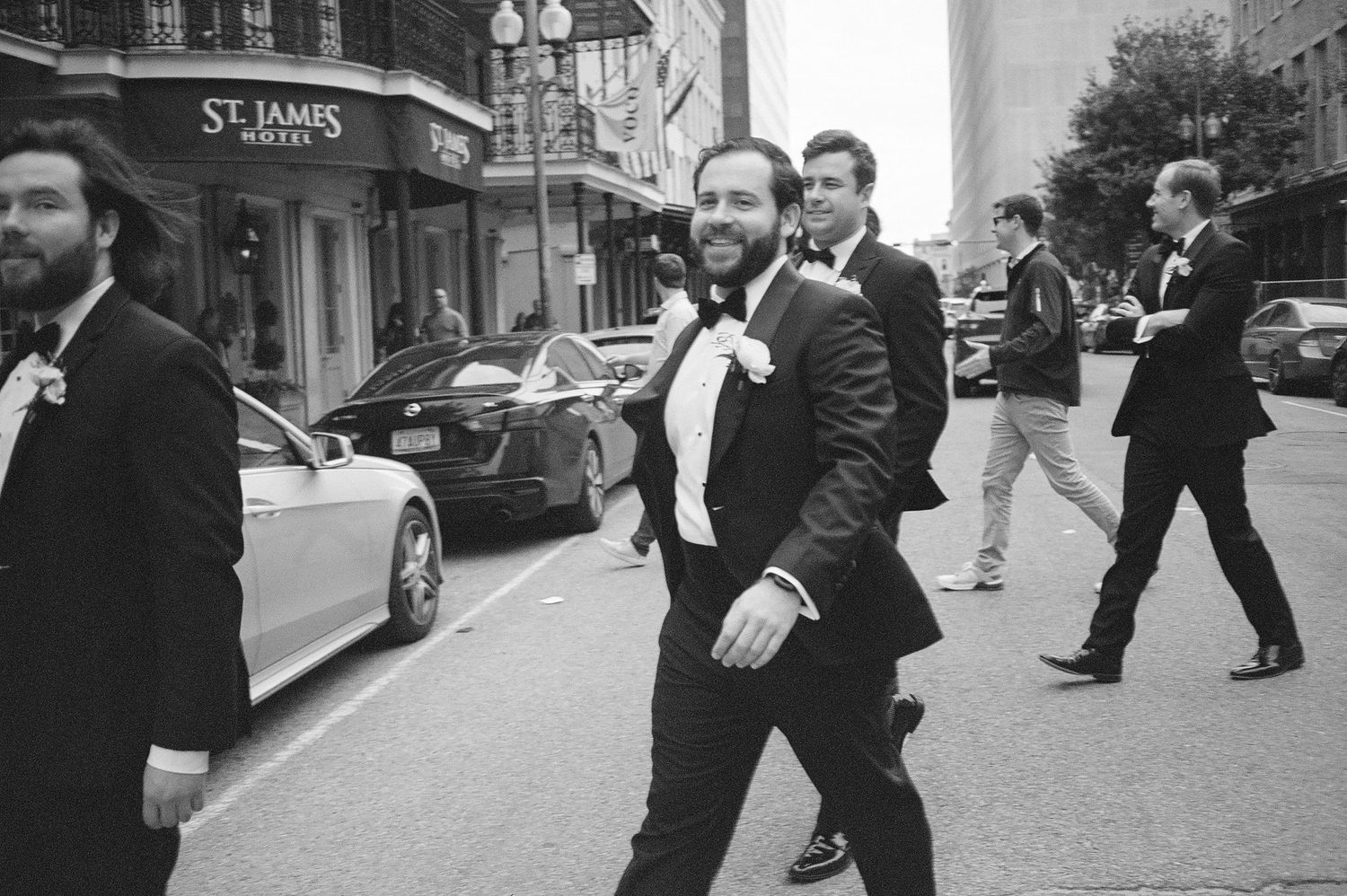 A group of formally dressed men walk down a city street together.