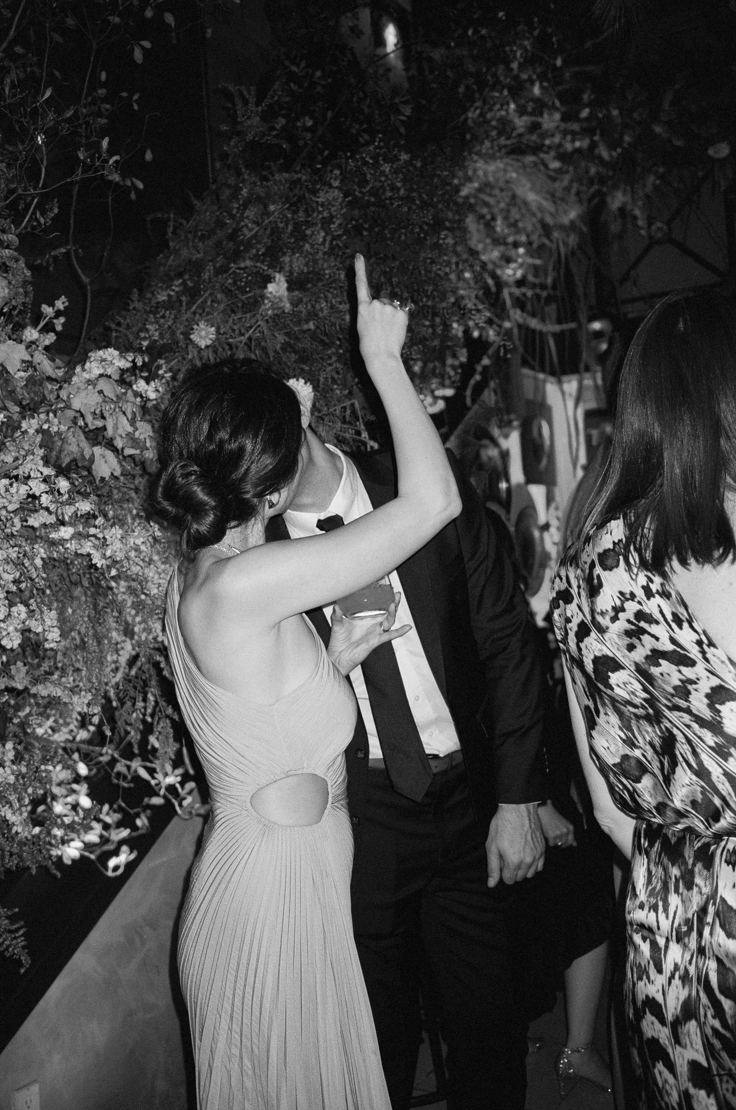 Wedding guests dance and celebrate at a nighttime outdoor reception.