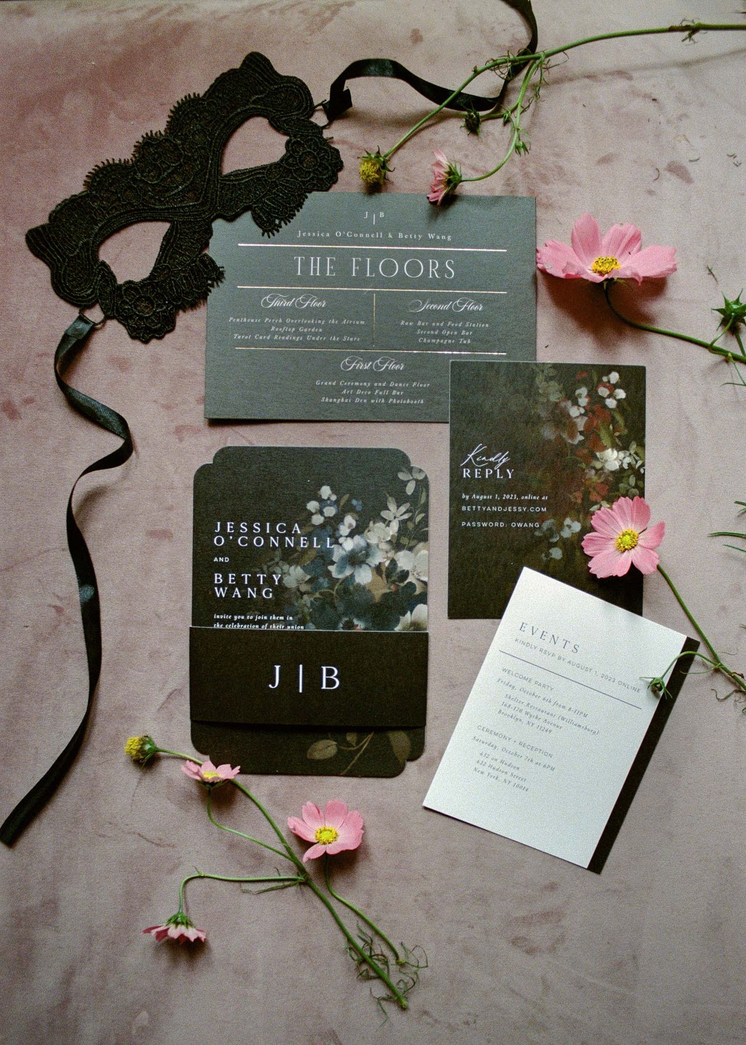 Modern gray and white wedding invitations arranged with pink flowers and black ribbon.