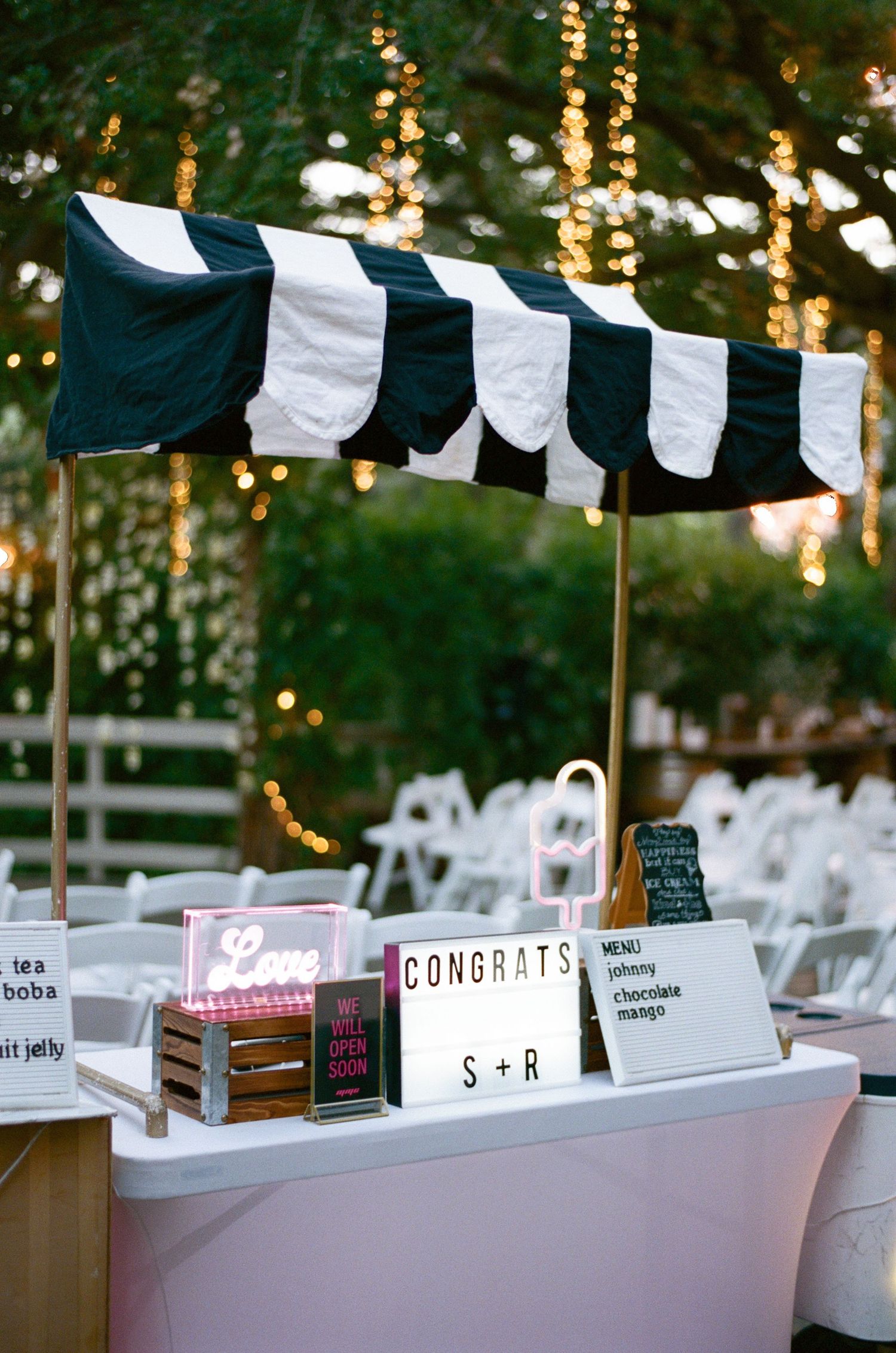 Wedding reception table with navy and white banners and congratulatory signs.