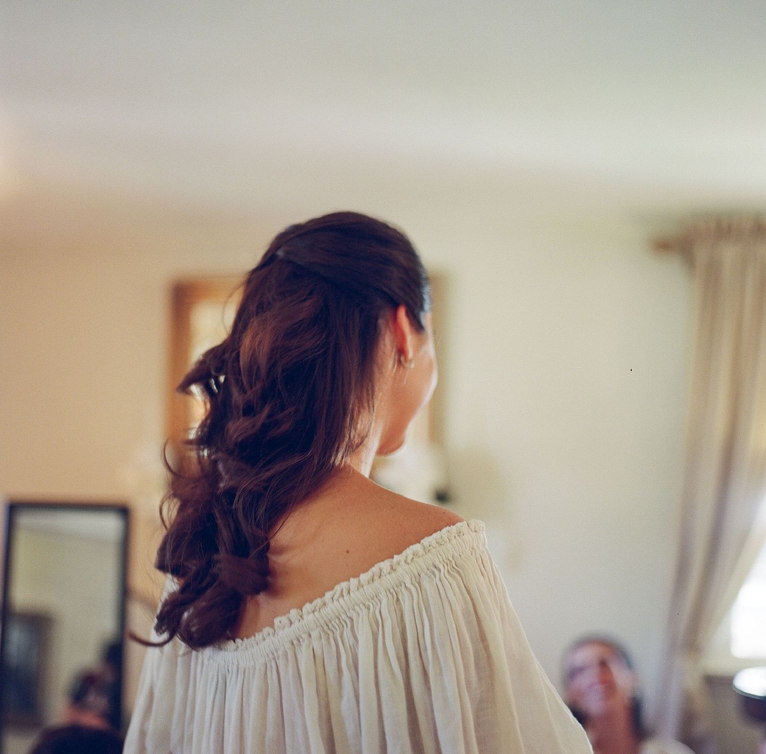 Wedding preparation scene showing details of an off-shoulder dress.