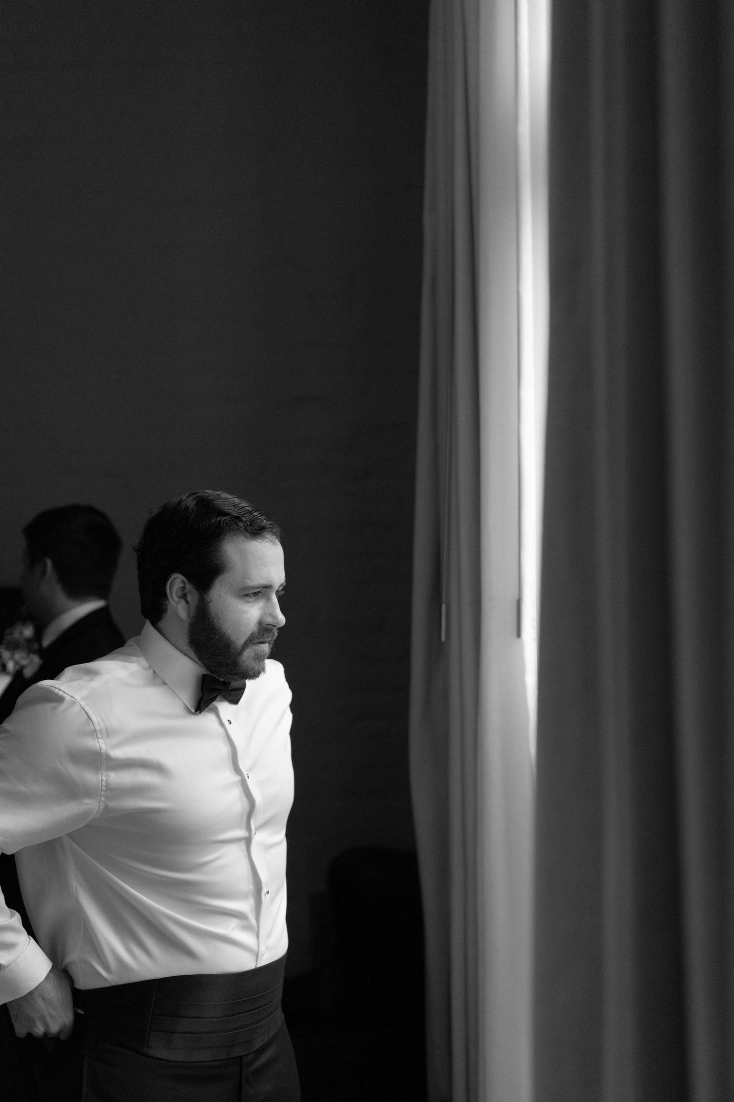 Artistic black and white sequence showing movement near a window with dramatic lighting.