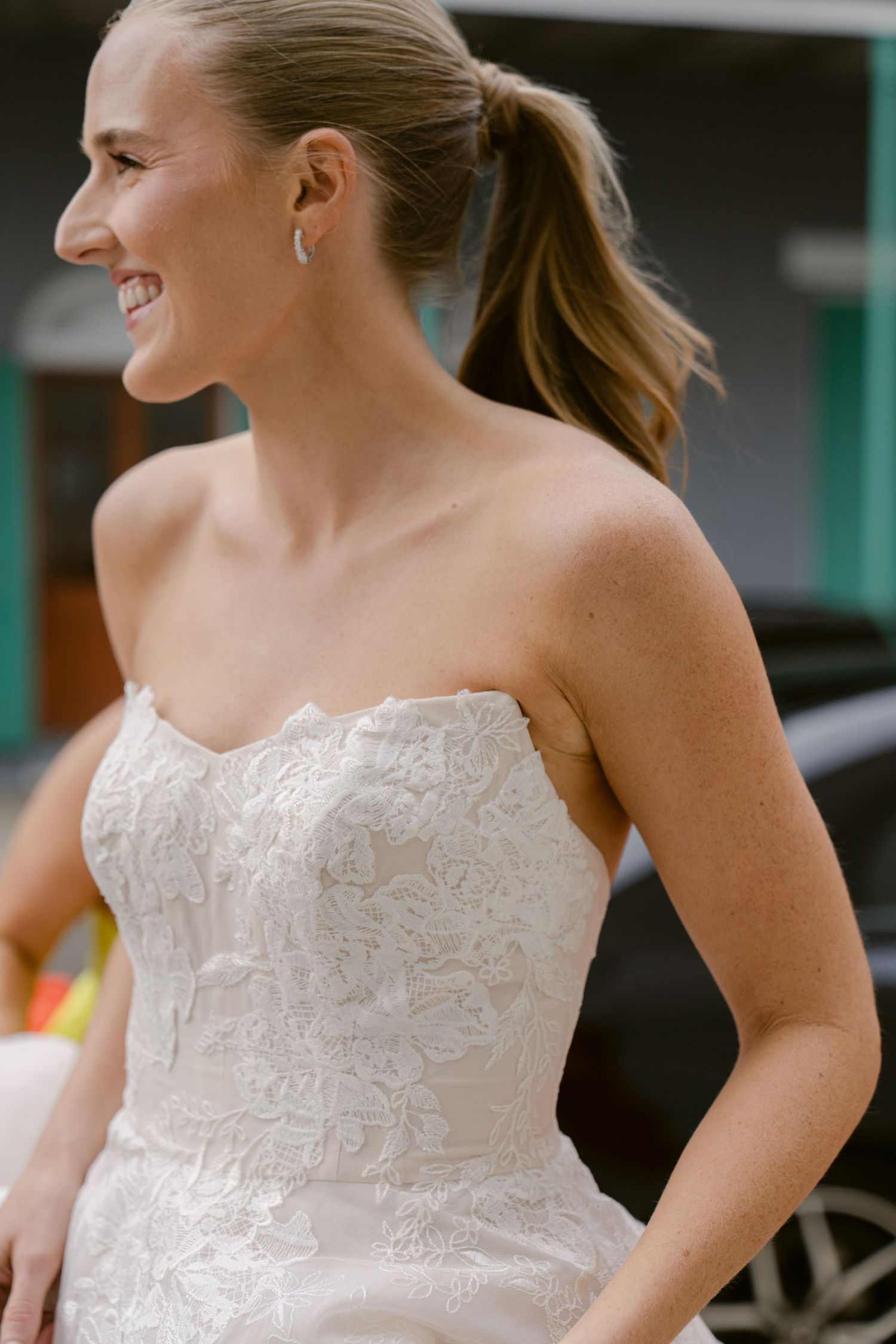 Elegant strapless wedding dress with detailed lace bodice shown in profile.
