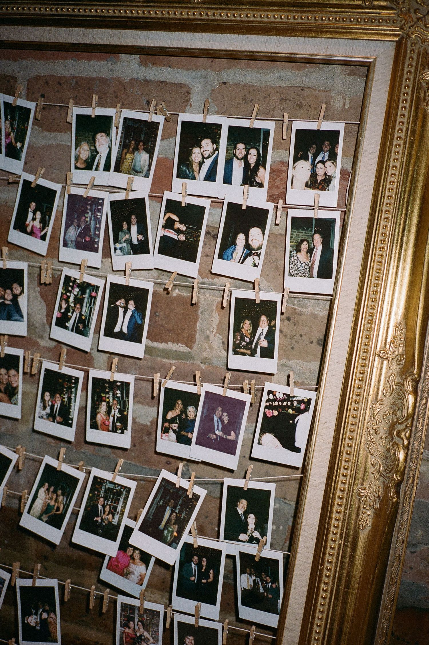 Vintage-style polaroid photos displayed on wall at wedding reception.