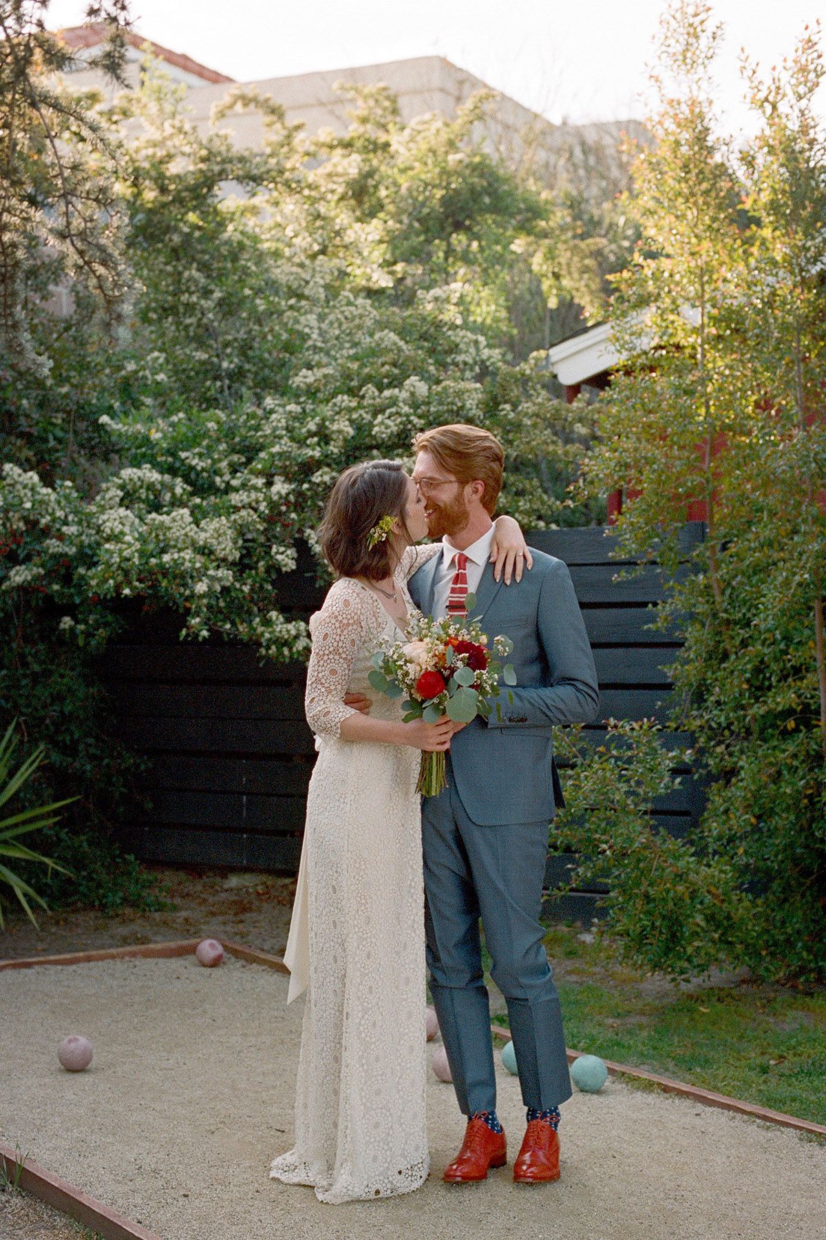 A couple embraces in an outdoor garden setting during their wedding portraits.