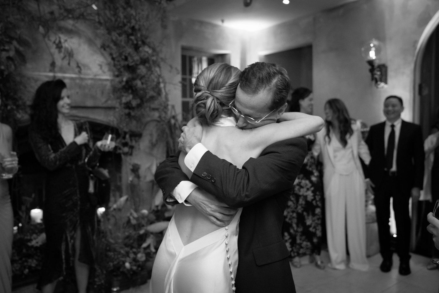 Wedding guests dancing and celebrating together at an elegant indoor reception venue.