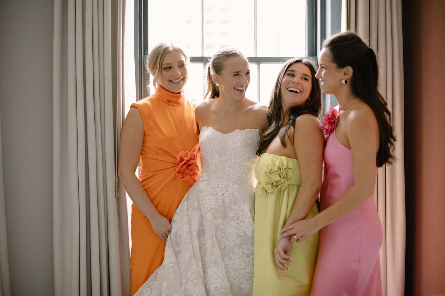 Bridesmaids in colorful dresses helping with wedding preparations.
