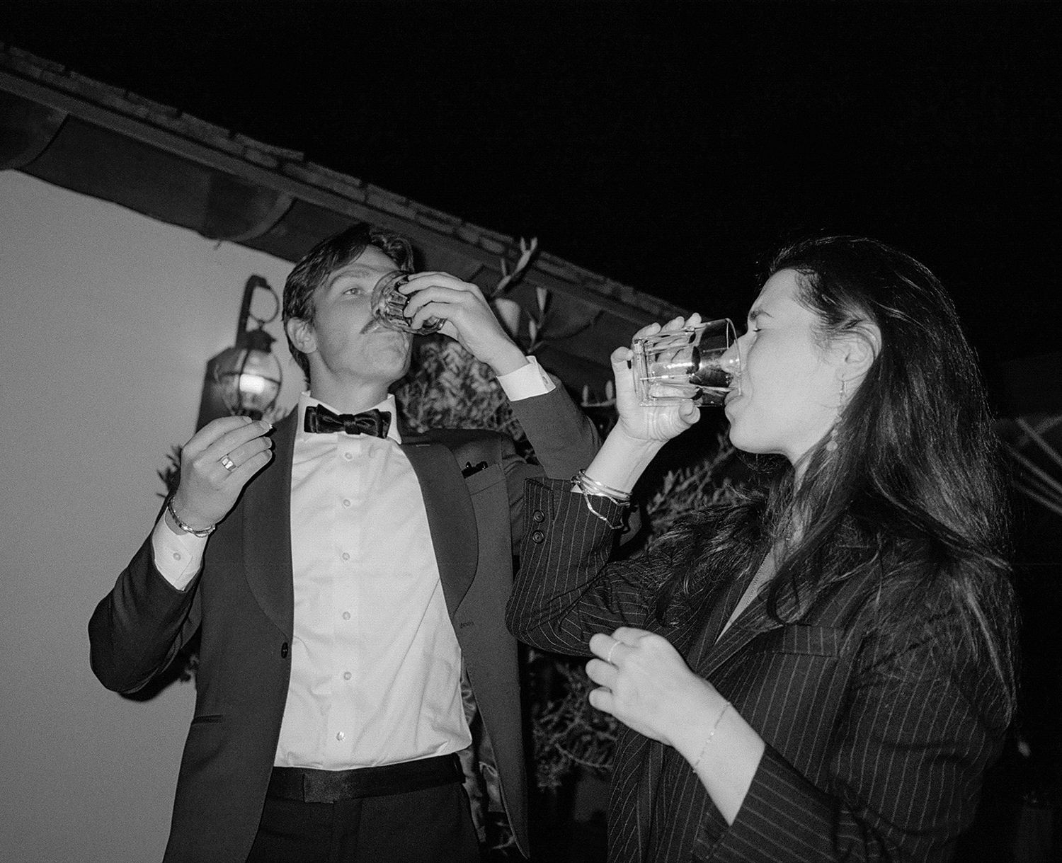 Group of party guests drinking and celebrating at a lively nighttime event.