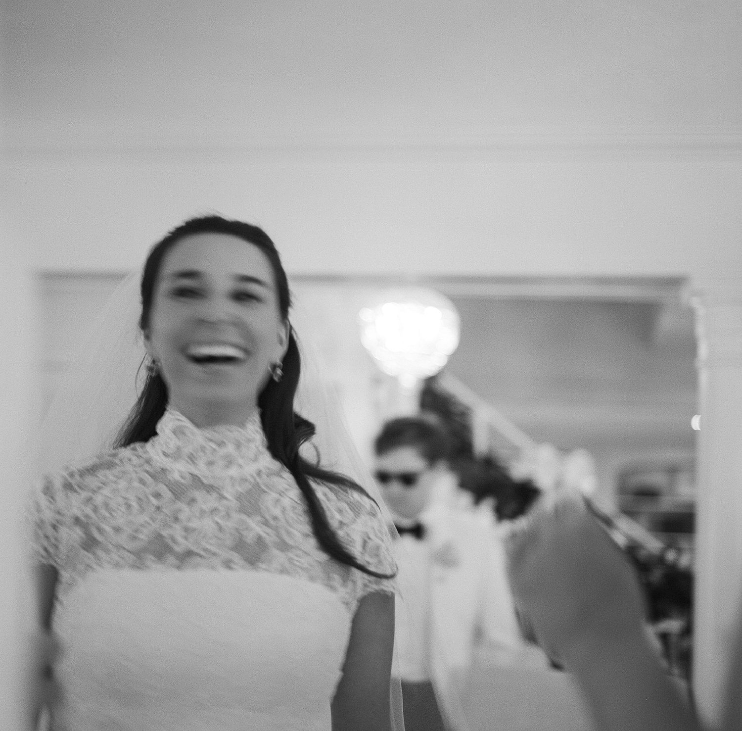 A candid black and white portrait capturing a joyful moment at a wedding.