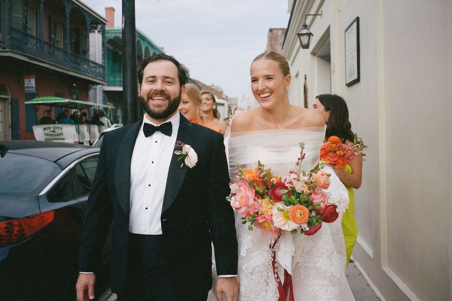 A couple shares a joyful moment together during their wedding celebration outside a historic venue.