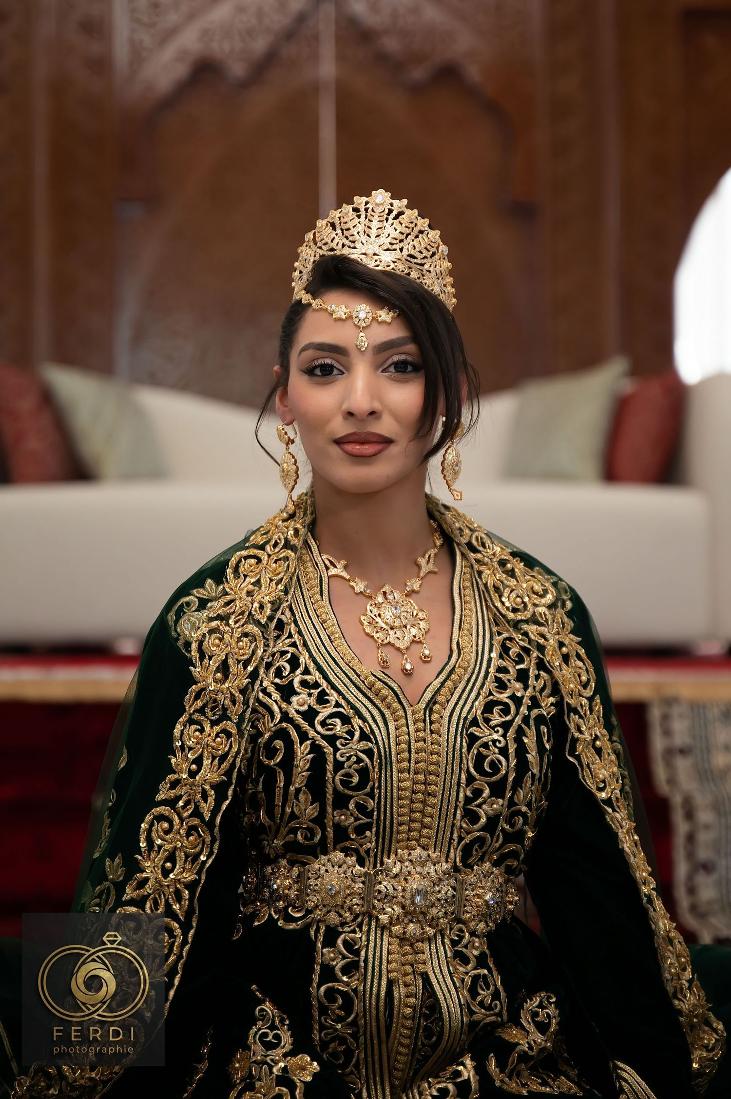 Traditional Moroccan wedding attire featuring an elegant black and gold embroidered kaftan with ornate jewelry and crown.