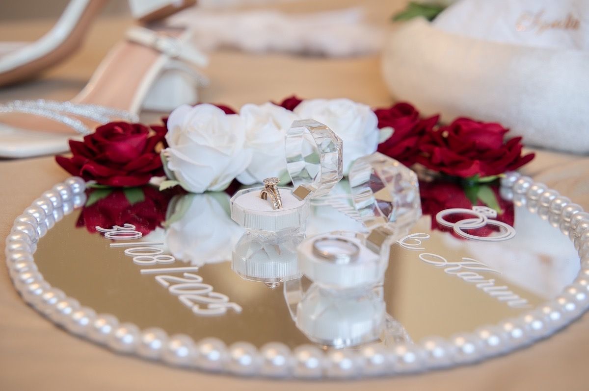 Red and white roses arranged with pearls on a decorative plate for wedding decor.