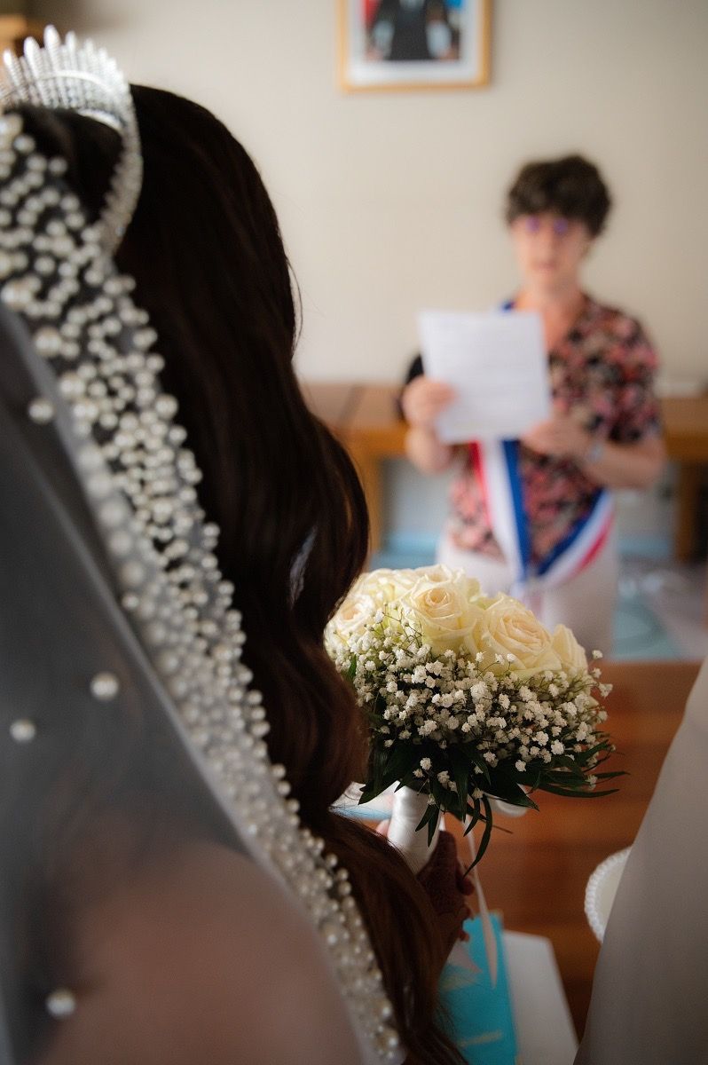 A close-up view of a delicate baby's breath floral crown worn at a wedding ceremony.