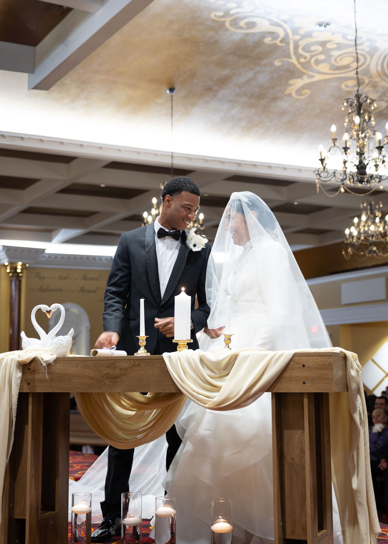 Bride and groom stand at altar during elegant wedding ceremony with candles and swan decorations. Bedford, VA