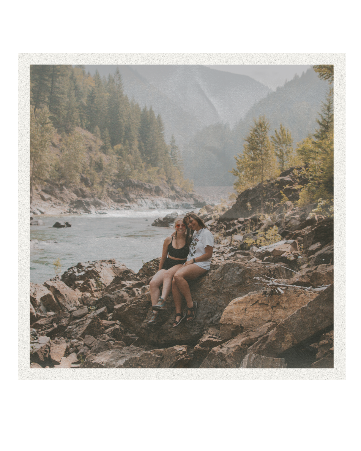 Scenic mountain river view with person resting on rocky shore.