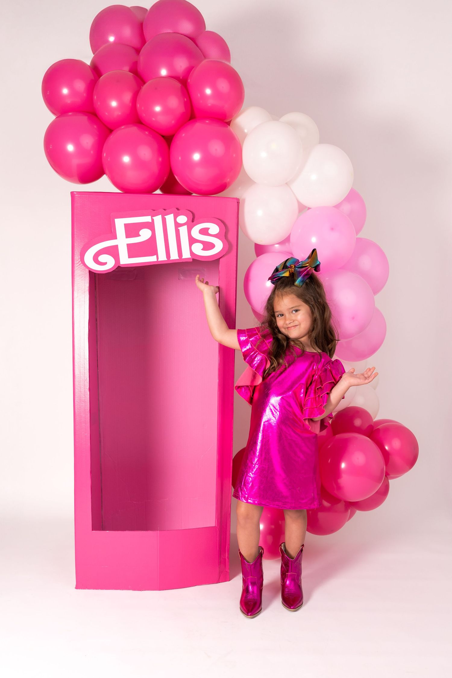 Pink photo booth display decorated with bright pink and white balloons and Ellis name branding against white backdrop.