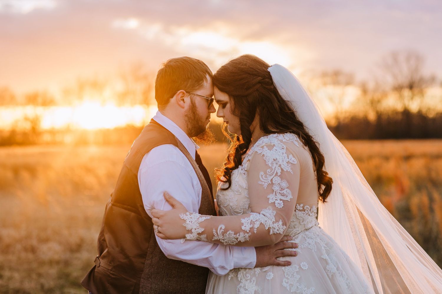 Romantic sunset wedding photos captured in a golden field during magic hour with lens flare effects.
