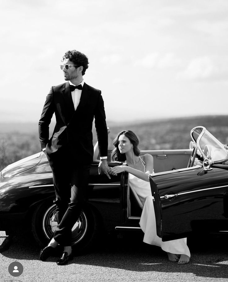 Elegant black and white photo series of a couple posing with a vintage luxury car in formal attire.