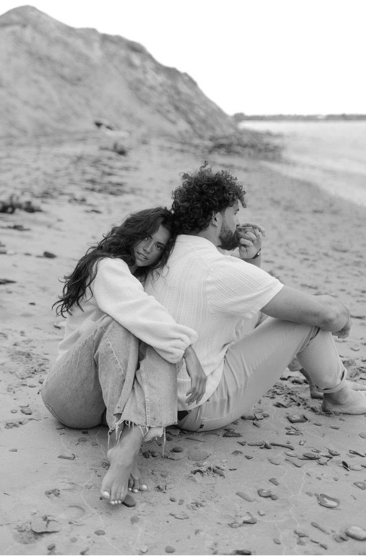 A black and white series of photos showing a person in a white shirt lying on a sandy beach.