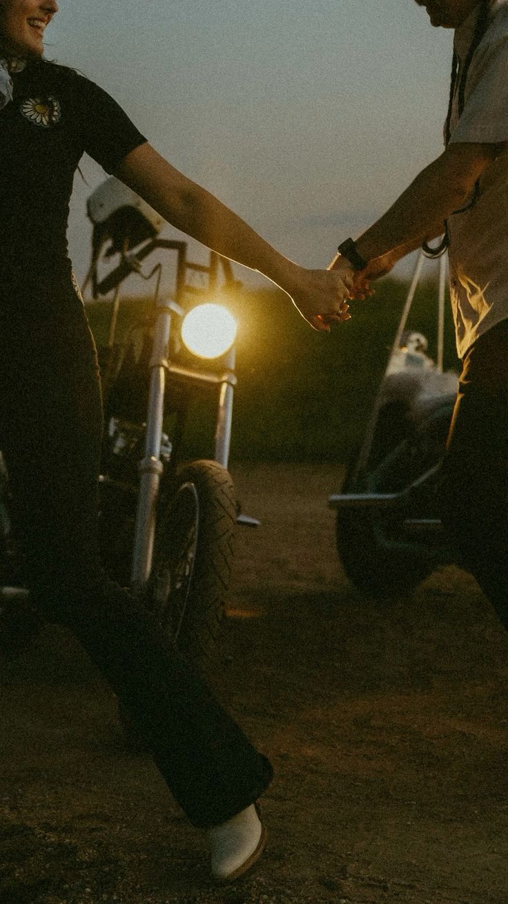 Silhouetted figures holding glowing lanterns at dusk create a moody atmospheric scene on a dirt path.