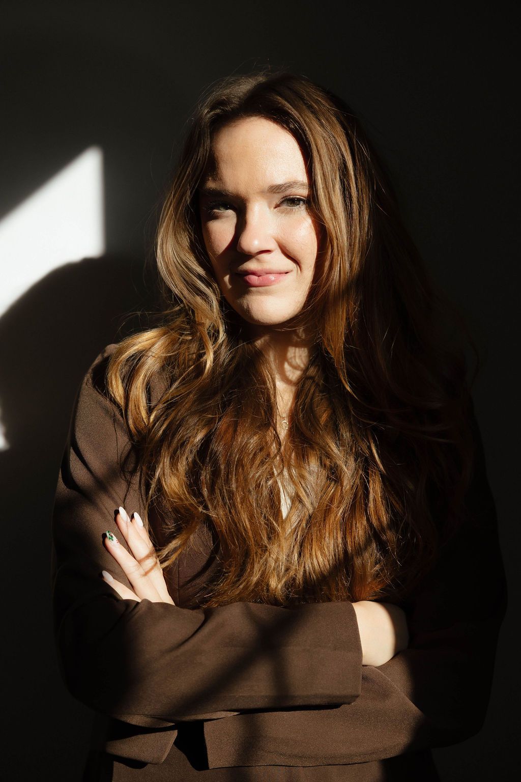 Artistic portrait series with dramatic lighting shows a person in a brown sweater against a dark background.
