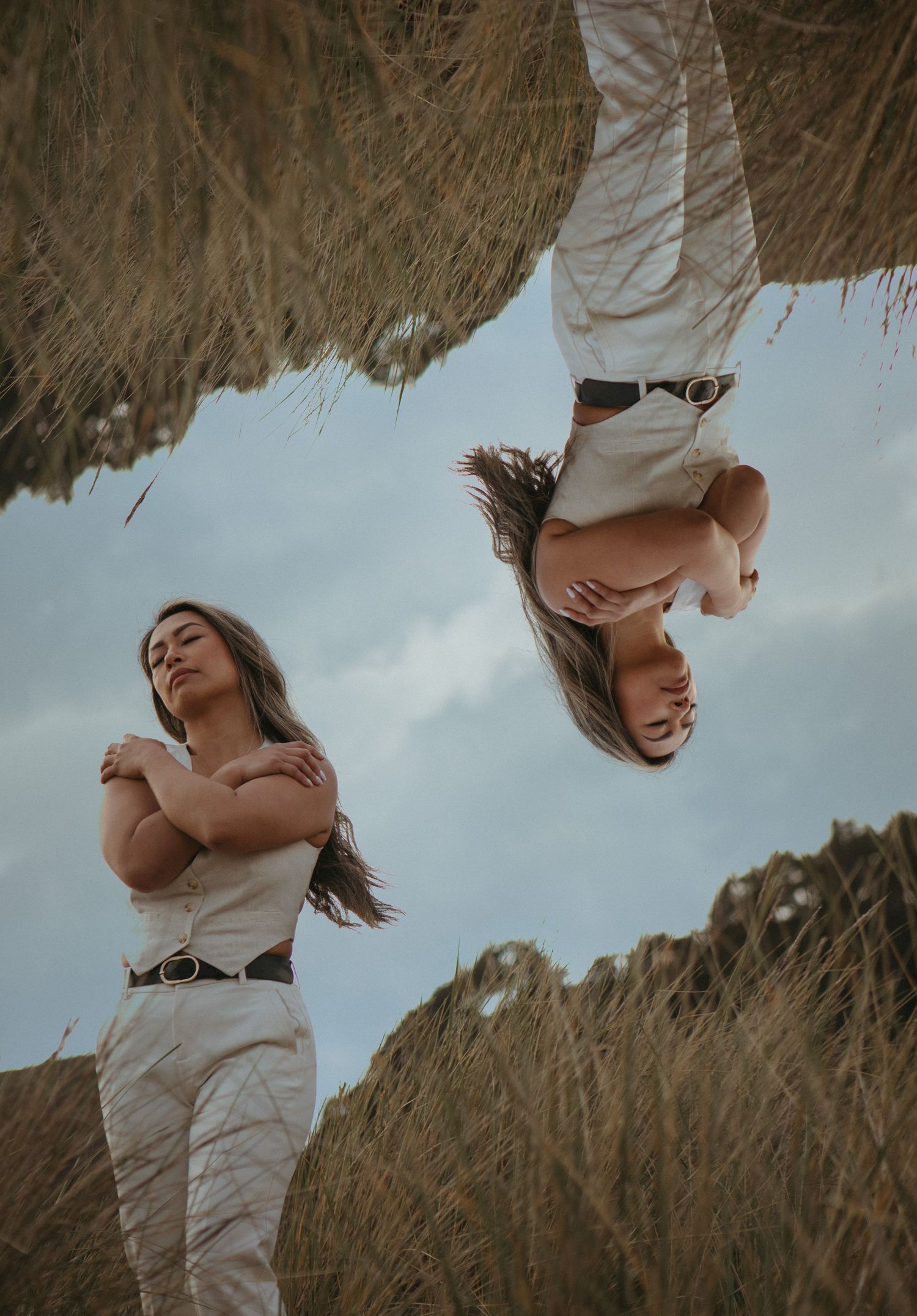Artistic portrait of someone dancing in a wheat field at sunset with flowing dress and hair movement.
