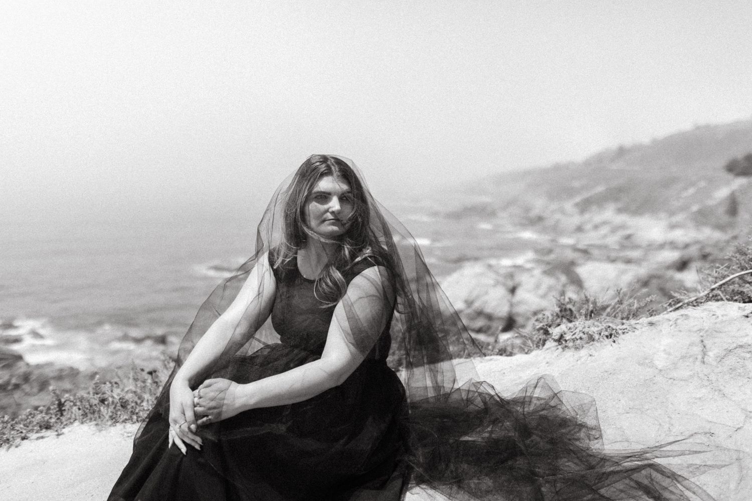 A series of black and white photographs showing people reclining on rocky cliffs overlooking a scenic mountain landscape.