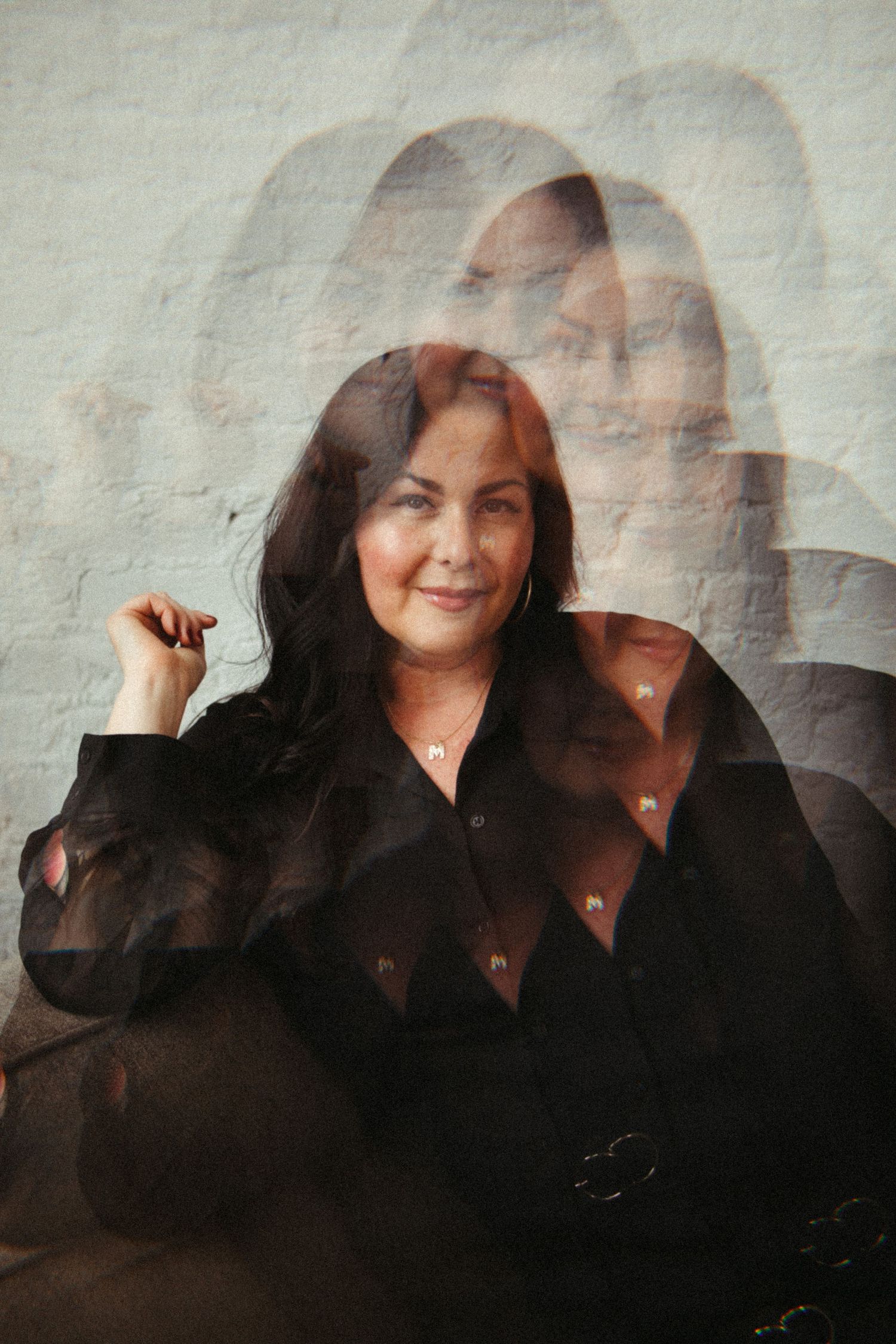 Multiple exposure portrait showing progressive movement in a dark silhouette against a light background.