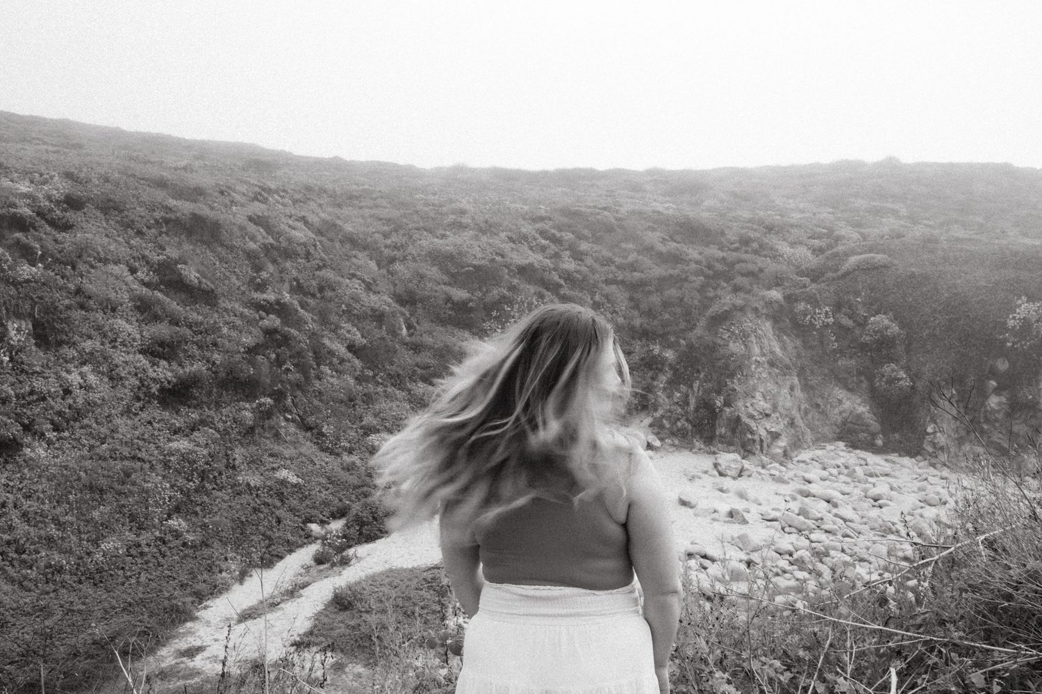 A series of black and white landscape photographs showing rolling hills and coastal scenery.