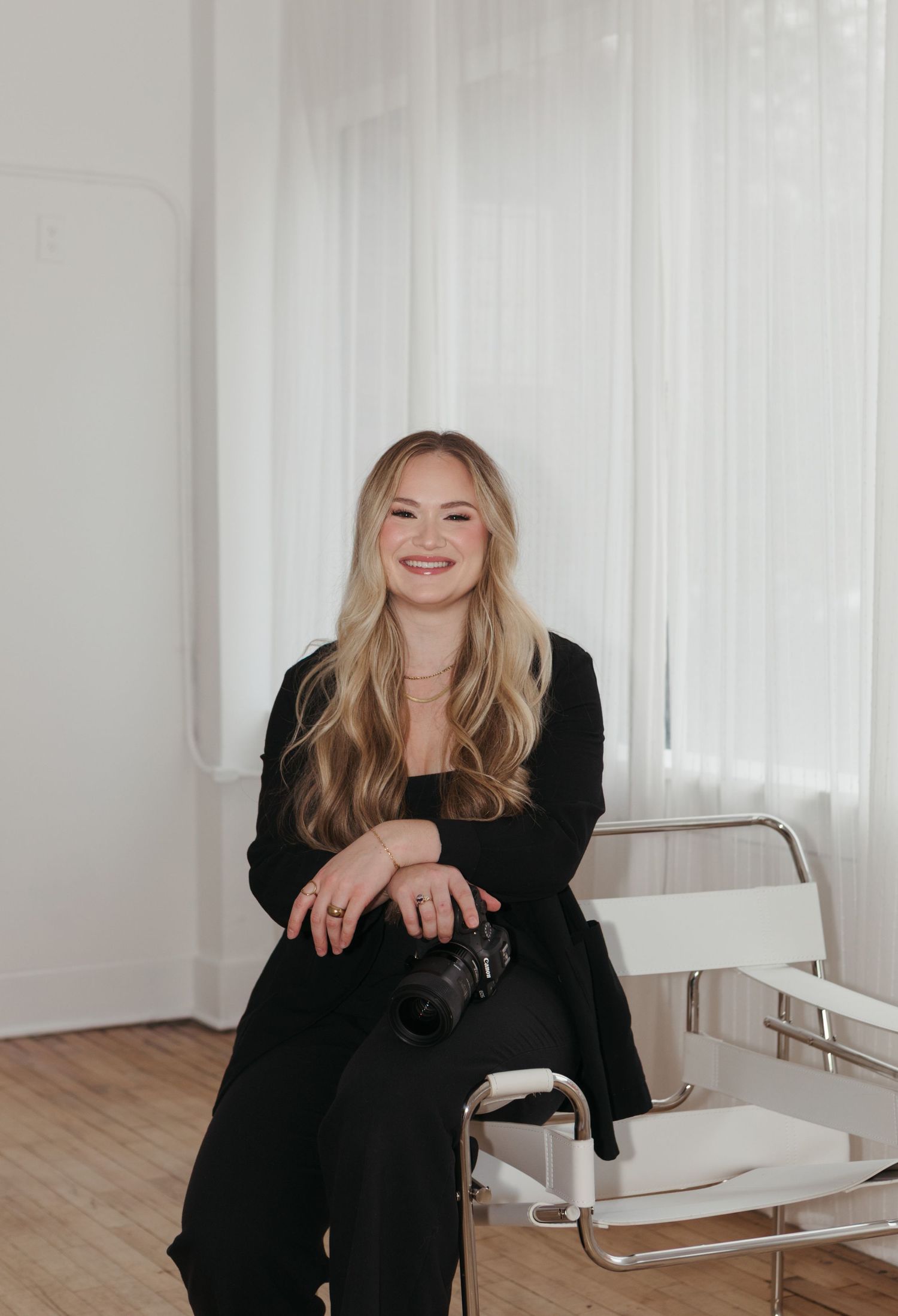 A series of candid shots showing someone in a black outfit sitting and laughing on a white chair in a bright room.