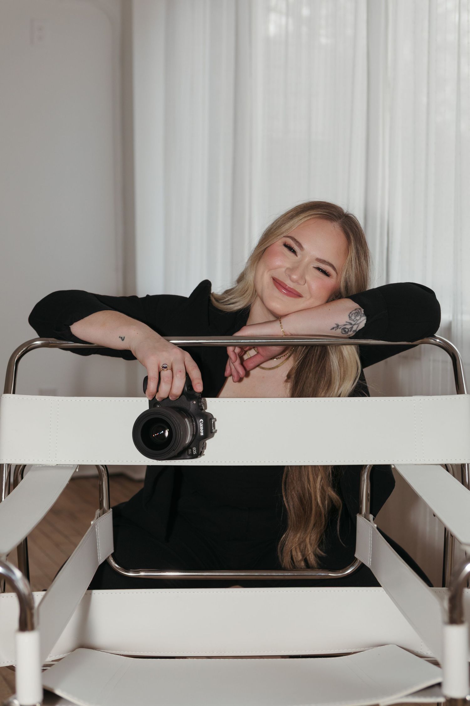 Person in black attire lounges elegantly across white modern shelving unit in bright interior setting.