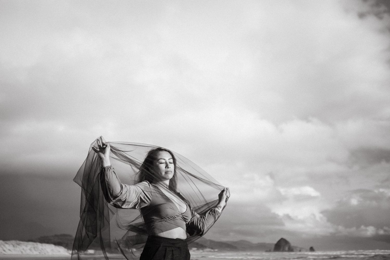 A black and white panoramic sequence shows a figure dancing gracefully against a cloudy sky backdrop.