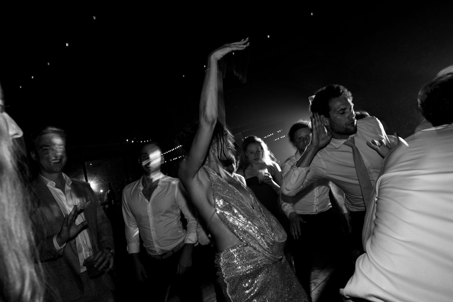 People dance and celebrate together on a crowded dance floor at a party or nightclub event.
