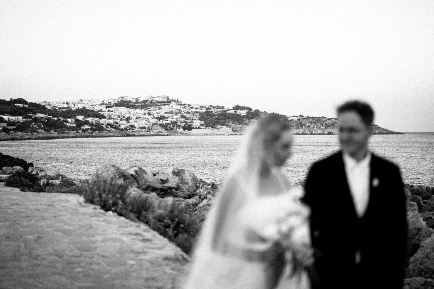 A collection of vintage black and white wedding photographs arranged in a horizontal strip shows seaside ceremony moments.
