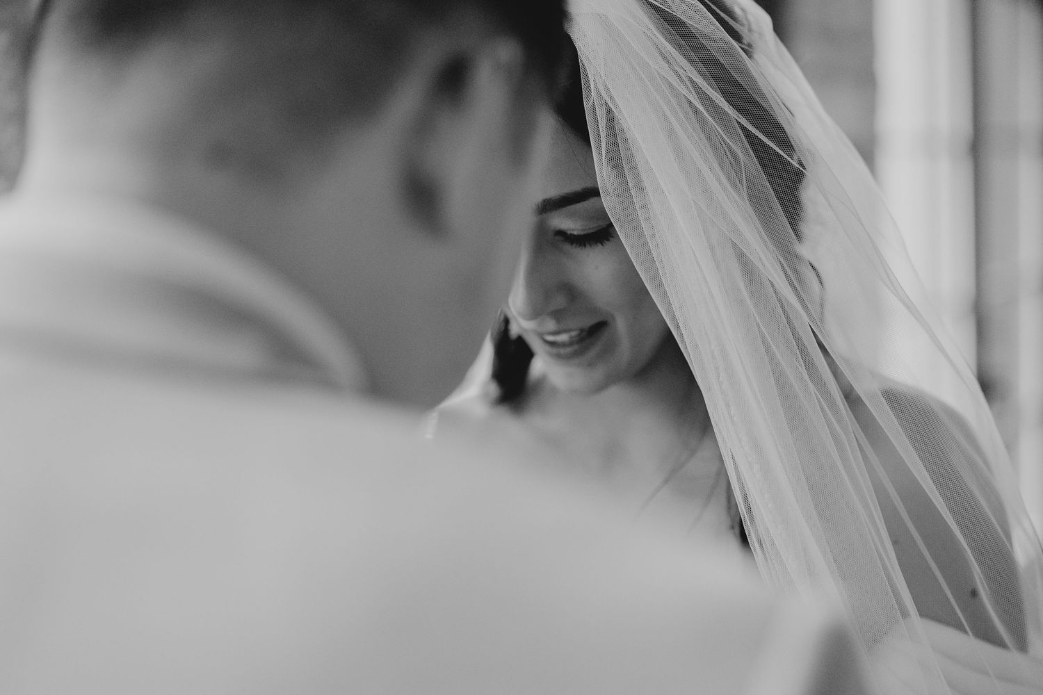 Black and white close-up of tender wedding moment.