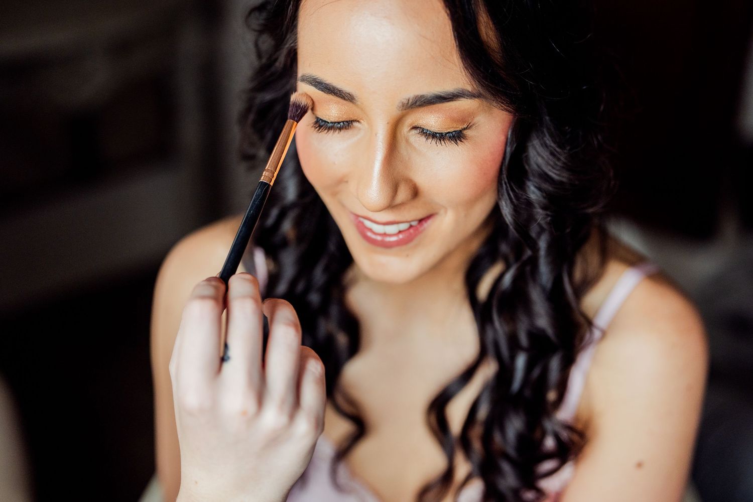 Close-up shots of wedding day makeup preparation in black and white.