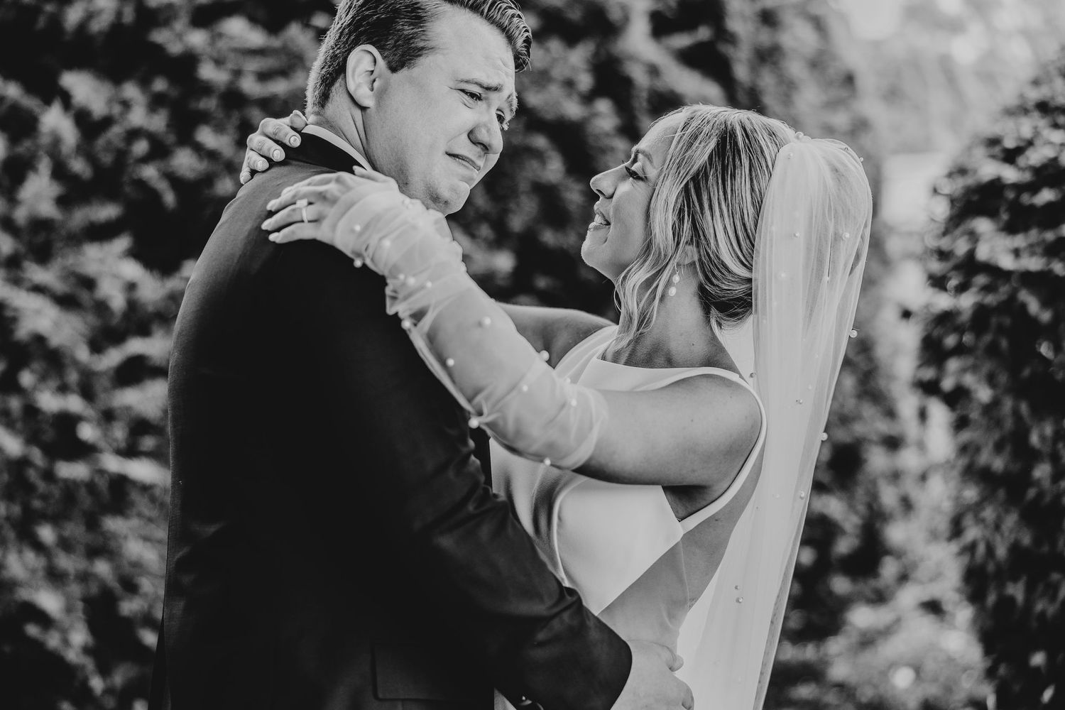 Intimate black and white wedding portraits captured in a garden setting.