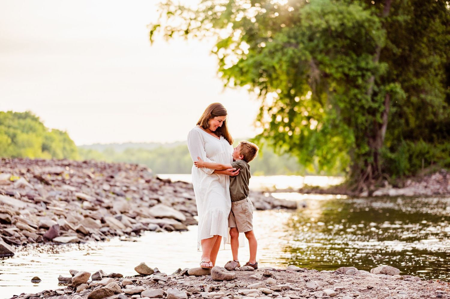 Sunset family photography session along rocky riverbank.