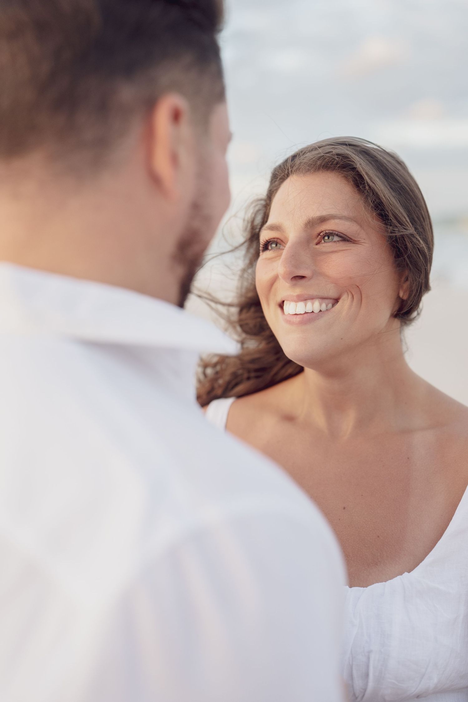 Side profile shots capturing genuine smiles and emotional moments between a couple.