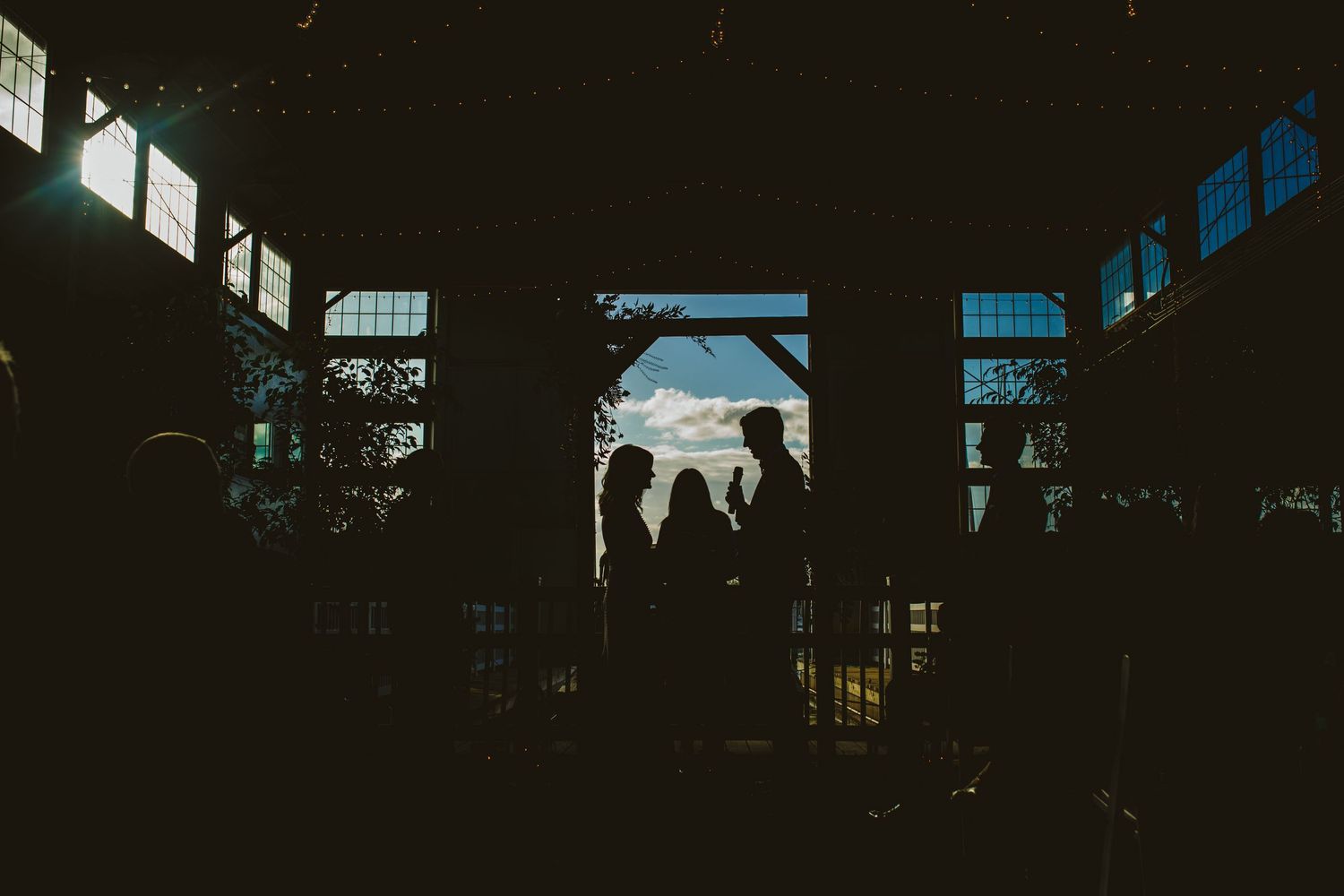 Dark interior venue with window light creating dramatic silhouettes.