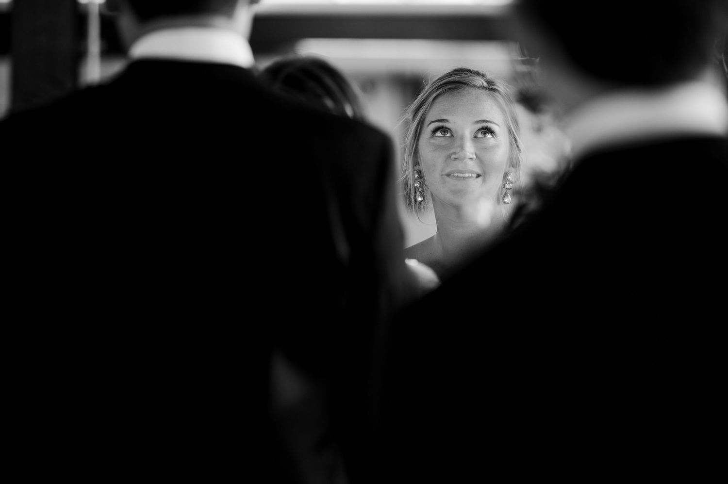 Black and white candid reception photo capturing intimate moments in low light.