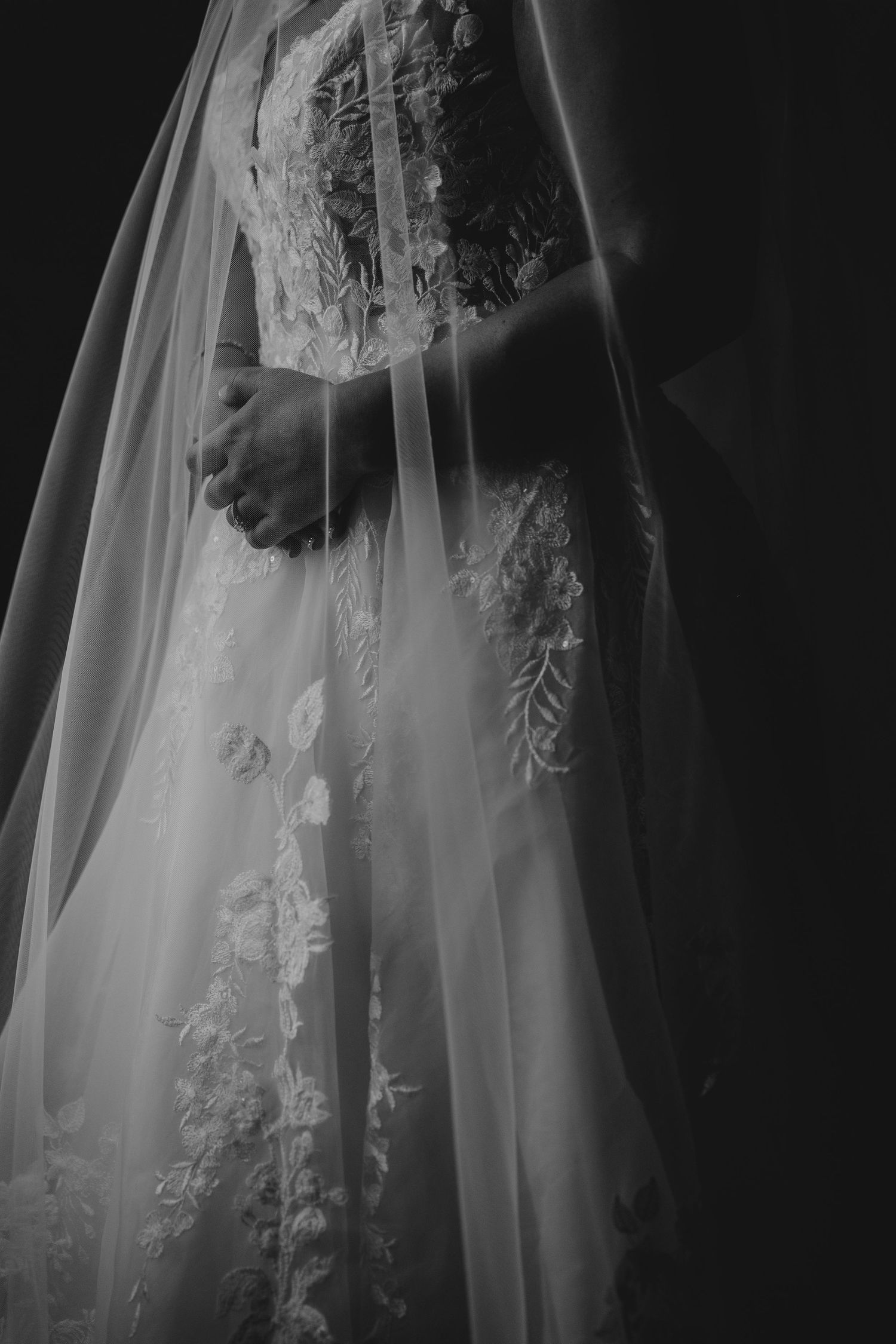 Ethereal bridal portrait featuring delicate lace details and flowing veil in monochrome.