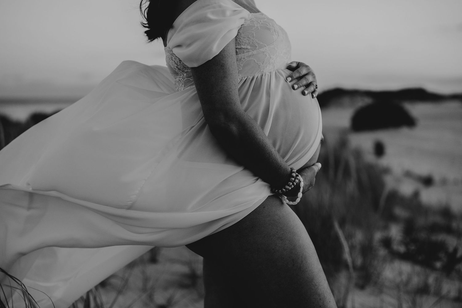 Black and white photo capturing a tender moment between a couple outdoors.