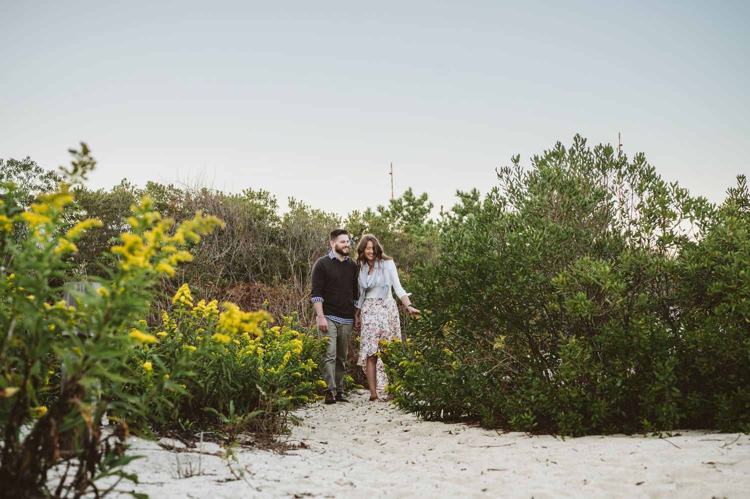 Wedding photo shoot in a natural setting with green foliage and beach elements.