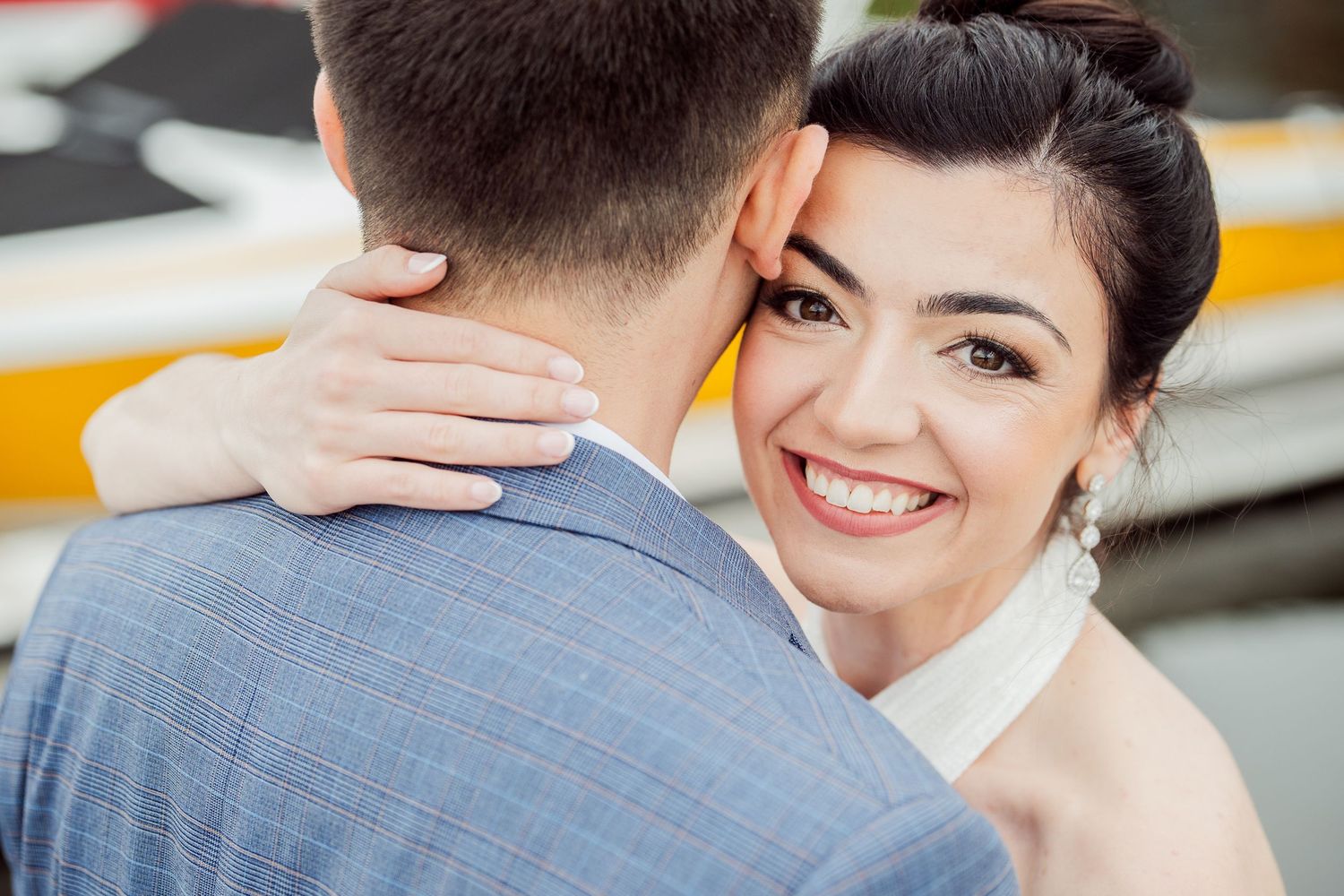 Candid wedding photo capturing a bride's radiant smile while embracing her groom.