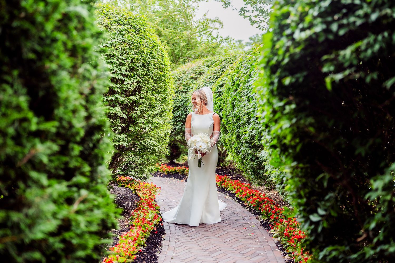 Garden wedding ceremony setup with colorful flower borders and greenery.